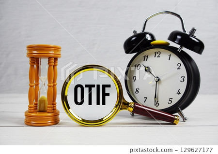 OTIF abbreviation of On Time In Full text with alarm clock on wooden background 129627177