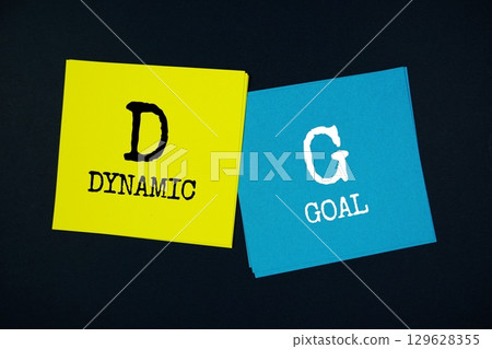 Dynamic Goal (DG) text message on stick note on black background Dynamic Goal (DG) text message on stick note on black background 129628355