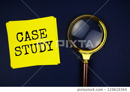 Case Study text with sticky note and magnifying glass on black background 129628368