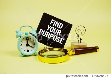 Find Your Purpose text message on sticky note with magnifying glass and alarm clock on yellow background Find Your Purpose text message on sticky note with magnifying glass and alarm clock on yellow background 129628424