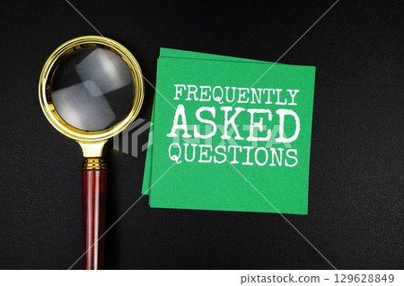 FAQ Frequently Asked Questions text with sticky note and magnifying glass on black background 129628849