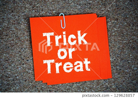 Trick or Treat text message on stick note on cork paper background 129628857