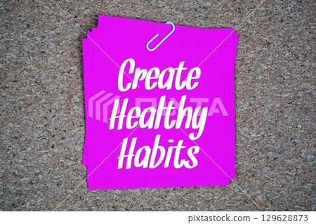 Create Healthy Habits text message on stick note on cork paper background Create Healthy Habits text message on stick note on cork paper background 129628873