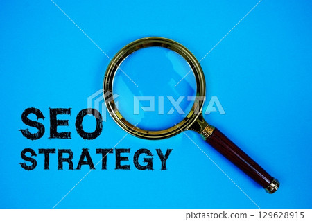 SEO Strategy text with magnifying glass on blue background 129628915