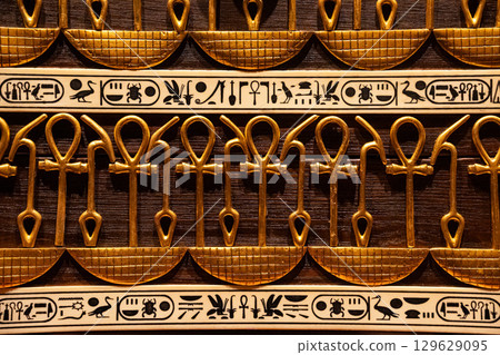Ancient Egyptian hieroglyphs and ankh symbols gold relief detail,ornate patterns 129629095