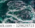 Blue waves of water of the river and the sea meet each other during high tide and low tide. 129629713
