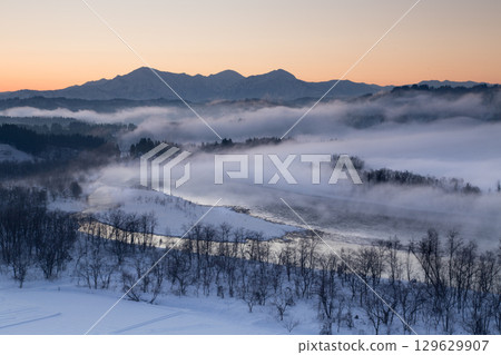 新潟縣小千谷市：日出時分，霧氣瀰漫的信濃川與雪景環繞的越後三山 129629907