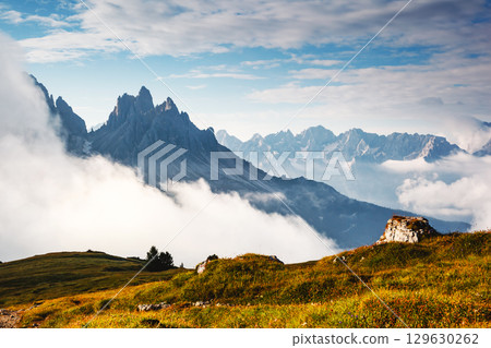 Highland scenery with high rocks and foggy valley on a sunny day. Location place Dolomites, South Tyrol, Italy, Europe. Highland scenery with high rocks and foggy valley on a sunny day. Location place Dolomites, South Tyrol, Italy, Europe. 129630262