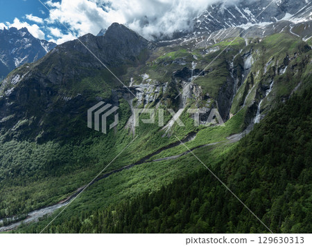 Aerial view of beautiful high altitude snow capped mountain and waterfall landscape Aerial view of beautiful high altitude snow capped mountain and waterfall landscape 129630313