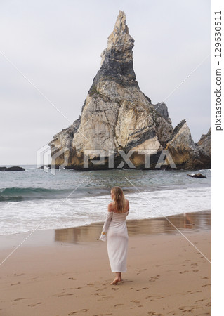 In Solitude by the Ocean A Woman Walking Alone Peacefully on the Beautiful Scenic Beachside In Solitude by the Ocean A Woman Walking Alone Peacefully on the Beautiful Scenic Beachside 129630511