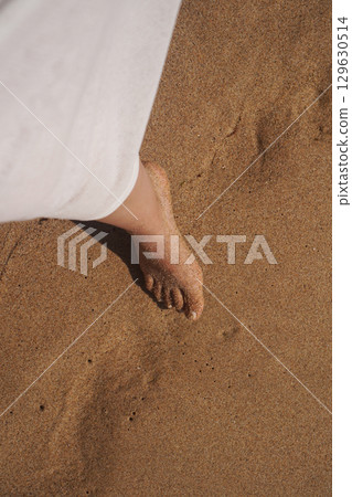 Experience the Peaceful Serenity of a Beautiful Beach with Barefoot Steps Enjoying the Sand Experience the Peaceful Serenity of a Beautiful Beach with Barefoot Steps Enjoying the Sand 129630514