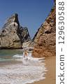 In Solitude by the Ocean A Woman Walking Alone Peacefully on the Beautiful Scenic Beachside 129630588