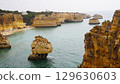 The coastal cliffs and stunning golden beach views create an unforgettable experience 129630603