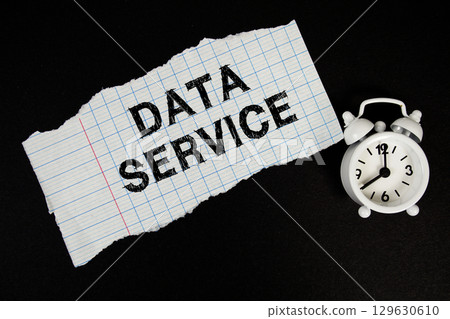 Data Service text written on paper with alarm clock on black background 129630610