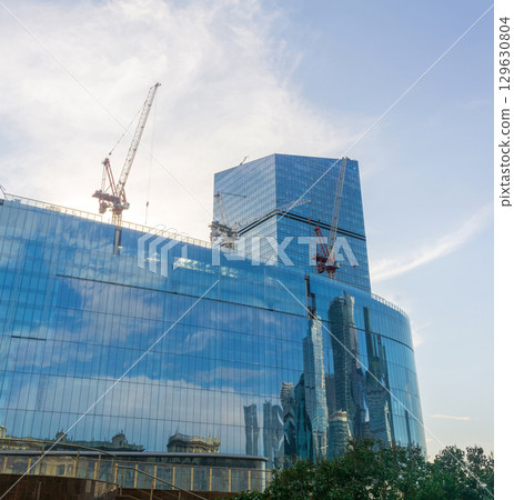 modern office building under construction in the blue sky background modern office building under construction in the blue sky background 129630804