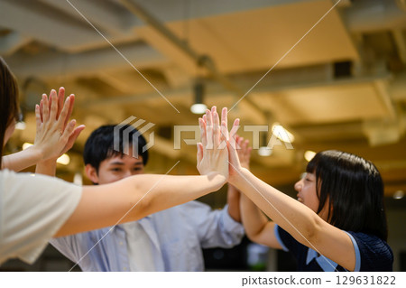 Male and female students exchanging high fives Male and female students exchanging high fives 129631822