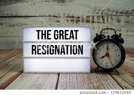 The Great Resignation text on light box with alarm clock on wooden background The Great Resignation text on light box with alarm clock on wooden background 129632084