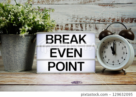 Break even point text on light box with alarm clock on wooden background Break even point text on light box with alarm clock on wooden background 129632095