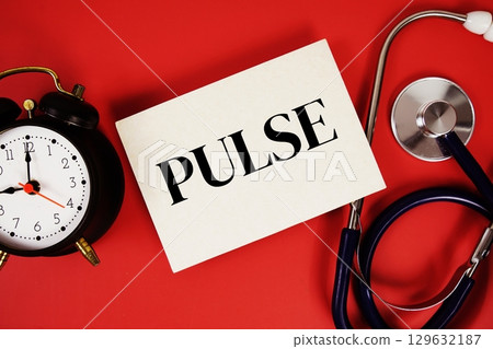 Pulse text written on paper card with stethoscope and alarm clock on red background 129632187