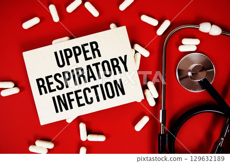 Upper Respiratory Infection text written on paper card with stethoscope and medicine capsule on red background 129632189