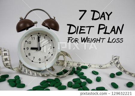 7 Day Diet Plan For Weight Loss text with medicine, alarm clock and measuring tape on white background 7 Day Diet Plan For Weight Loss text with medicine, alarm clock and measuring tape on white background 129632221