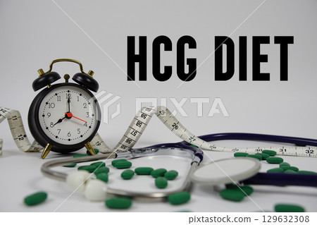 HCG Diet text with Stethoscope, medicine, measuring tape and alarm clock on white background 129632308