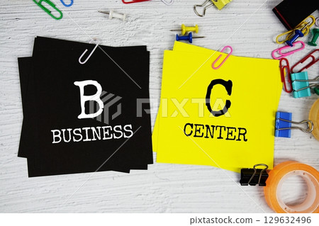 BC  - Business Center text on stick note with stationery on concrete background 129632496