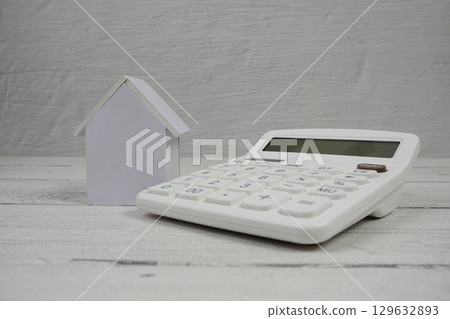 House Model and Caculator on wooden background House Model and Caculator on wooden background 129632893
