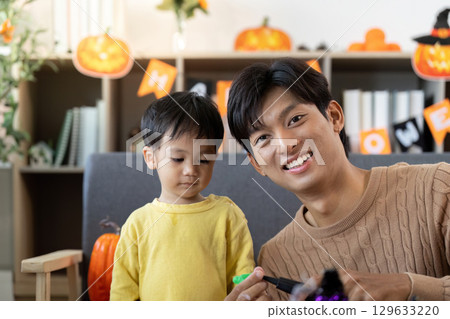 Halloween Fun. Father and son creating festive decorations together. Halloween Fun. Father and son creating festive decorations together. 129633220