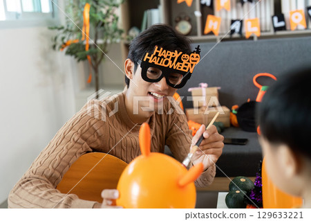 Festive Halloween Fun. Father and son creating decorations together. Festive Halloween Fun. Father and son creating decorations together. 129633221