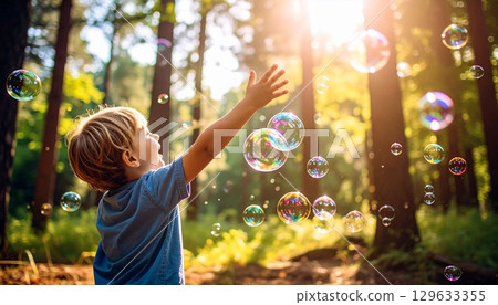Happy children playing with soap bubbles 129633355