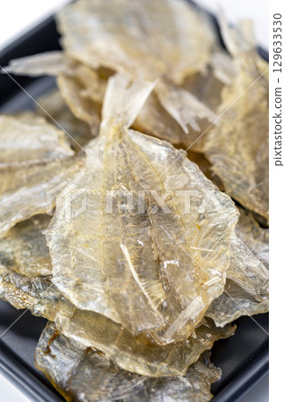 Dried sweet fish in a black plate. Scientific name is Parambassis siamensis. It is a type of food preservation. 129633530