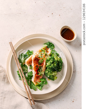 Captivating Capture: Exquisite Sea Bass with Broccoli in Asian style. Perfect Visual for Fish Food Menu Background. Delicious Baked Seabass with Broccoli And Sauce in Restaurant-style Plating. Topview 129634186