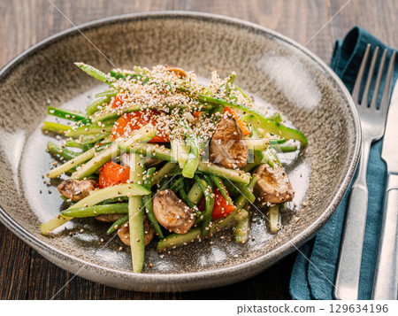 Delicious pork, veal or beef salad with cucumber in asian style with amaranth popcorn or popped amaranth replaceable sesame. Idea salad recipe for healthy menu. Vibrant bright meat salad with cucumber 129634196