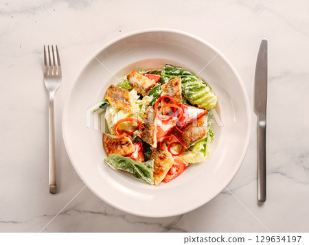 Delicious salad with fried baked smelt fish. Fried fish salad with fresh green lettuce, tomatoes, bell pepper. Ketogenic, keto or paleo diet lunch bowl. Ideas and recipe for fish lunch dishes menu 129634197