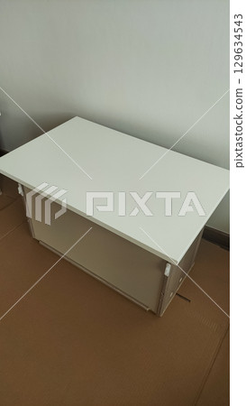 Installing modern furniture, white cabinet being assembled in prague apartment 129634543