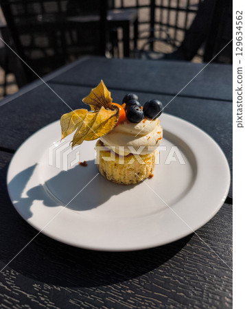 Mini cheesecake decorated with fresh fruit and cream on a table Mini cheesecake decorated with fresh fruit and cream on a table 129634562