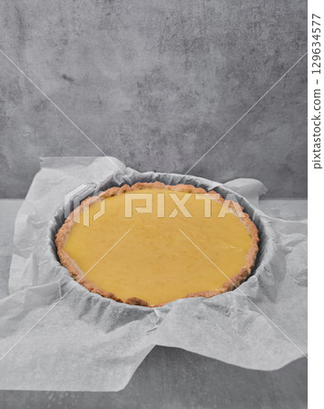 Freshly baked pumpkin pie or lemon tart cooling on baking paper Freshly baked pumpkin pie or lemon tart cooling on baking paper 129634577