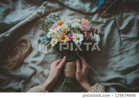Florist arranging colorful daisy bouquet for valentine's day 129634666