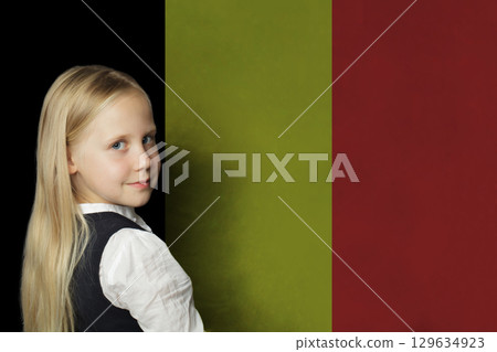 Smiling young child girl on flag of Belgium background. Education in Belgium concept 129634923
