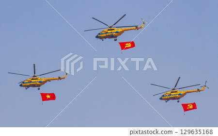 A Unit Mi-171 Helicopters Of Vietnam People's Air Force Flying With National Flag And Communist Party Flag At The 50th Anniversary Of The Reunification Day A Unit Mi-171 Helicopters Of Vietnam People's Air Force Flying With National Flag And Communist Party Flag At The 50th Anniversary Of The Reunification Day 129635168