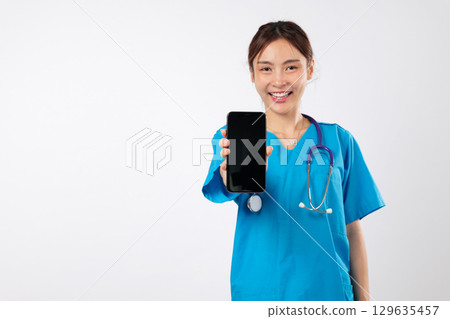 Asian woman show blank screen on mobile phone application as positive nurse in healthcare, service displays health treatment for dedicated work, confident nurse, headshot isolated white background Asian woman show blank screen on mobile phone application as positive nurse in healthcare, service displays health treatment for dedicated work, confident nurse, headshot isolated white background 129635457