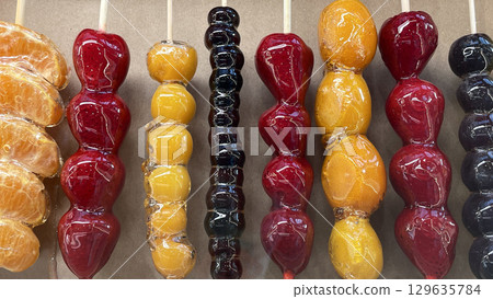 Chinese dessert Tanghulu made from crunchy caramelized fruit on a skewer. Sweet street food 129635784