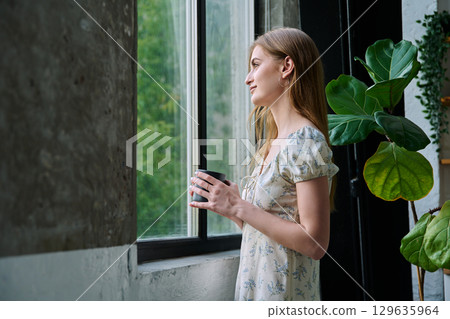 Young beautiful dreaming romantic girl looking out the window Young beautiful dreaming romantic girl looking out the window 129635964