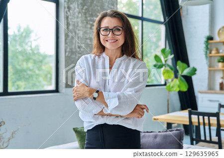 Portrait confident middle aged businesswoman posing with crossed arms 129635965