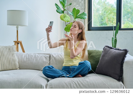 Smiling young teenage female taking selfie photo on smartphone Smiling young teenage female taking selfie photo on smartphone 129636012