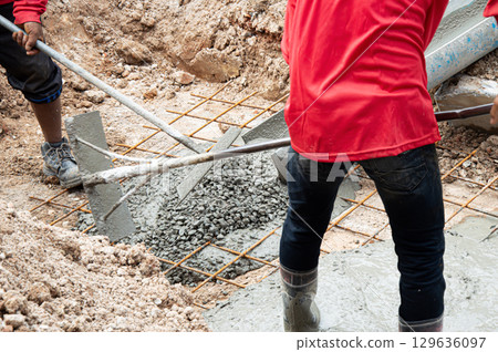 Workers are pouring cement on the construction site. Workers are pouring cement on the construction site. 129636097