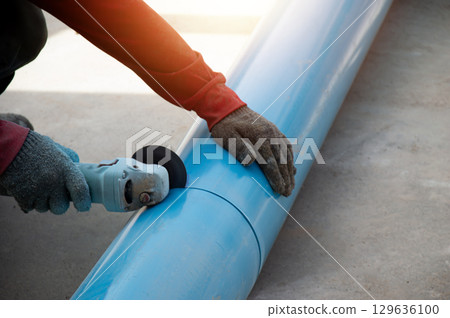 Workers are using PVC pipe cutting tools. 129636100