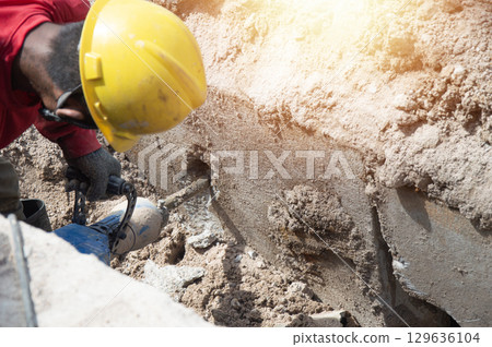 Workers are using a concrete hammer drill. 129636104