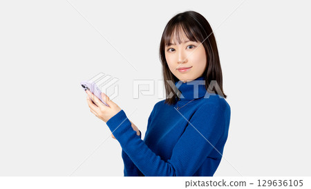 Smiling woman/businesswoman holding a smartphone 129636105